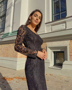 Rochie neagra din dantelă cu mâneci lungi și decolteu mic, ajustată pe corp.