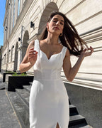 Rochie cocktail albă elegantă fără mâneci cu slit pe picior și croială ajustată, ideală pentru evenimente speciale.