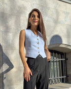 Vesta damă albastră cu croi cambrat și nasturi, material ușor elastic, decolteu în V.