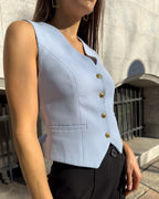 Vesta dama albastra cambrata din stofa elastica cu decolteu in V si nasturi.