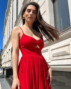 Rochie rosie midi elegantă cu decupaj frontal și bretele subțiri.