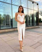 Rochie eleganta alba cu căptușeală și tăietură centrală, purtată de o femeie.