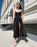Rochie neagra lungă cu bretele și slit pe piciorul stâng.